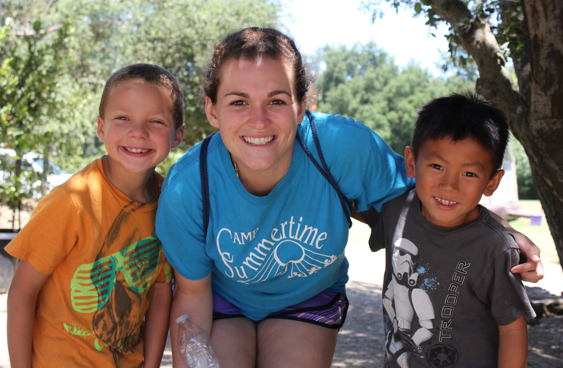 Two boys at Camp Summertime posing for a picture with their Camp Counselor.