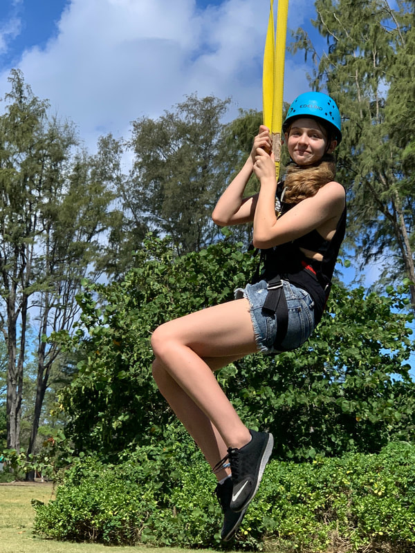 Girl enjoying the zip line activity at summer camp